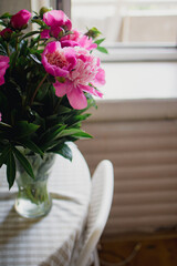 bouquet of pink peonies in a vase on the table - 591758484