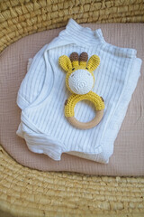 basket there are things for the baby and wooden and knitted toys-rattles. Natural natural minimalistic style. View from above - 591758621