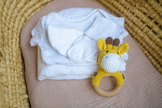 basket there are things for the baby and wooden and knitted toys-rattles. Natural natural minimalistic style. View from above