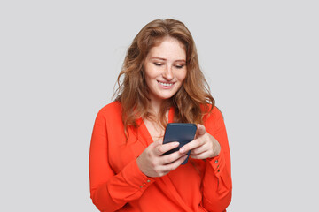 Happy smiling woman using smartphone, studio portrait