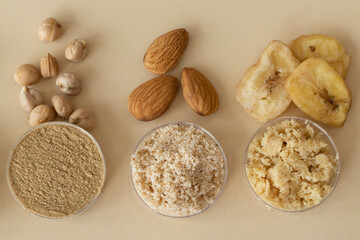 Mixed gluten-free chickpea flour, almond nuts and dried bananas on a beige background. Top view, close-up