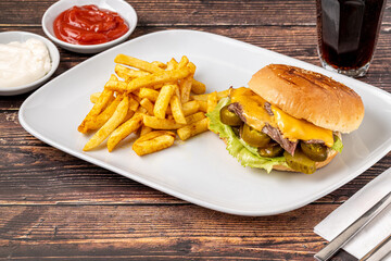 Delicious beef burger with french fries, onion rings and sauces