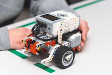 Teen girl student with diy robot on stem education class.Teen scientist working on new project.Stem education Learning To Program Robot Vehicle.