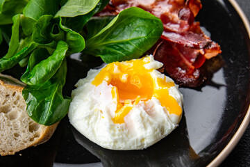poached egg breakfast bacon, green leaves salad mix meal food snack on the table copy space food background rustic top view