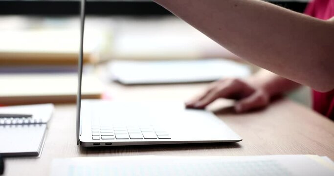 Female manager opens modern laptop to continue typing report. Woman ready to work on electronic device sitting at table in office slow motion