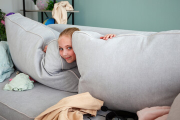 A girl is playing hide-and-seek. The child scattered things in the room. She doesn't want to put...