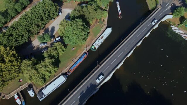 Aerial view rotating over vehicles driving on Clapton historical archway canal bridge, England