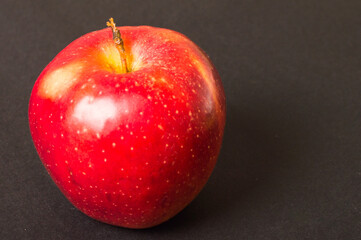 Healthy vegan fruit. Red apple on the black background. Eco food