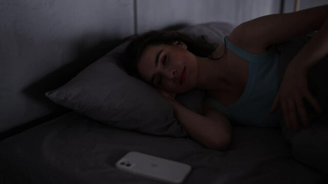 Young woman close phone and go to sleep in her bed