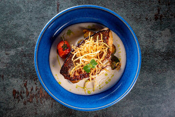 Fried fillet dorado fish with tomatoes, lemon and sauce on plate