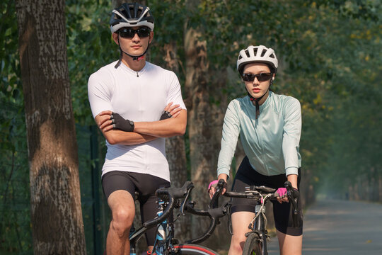 Cycling young couple standing in the woods