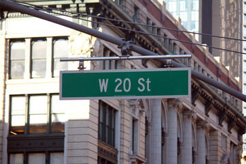Obraz premium Green big West 20th Street sign hanging on a arch pole in the streets of midtown Manhattan