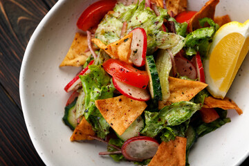 A delicious and nutritious salad featuring fresh vegetables and crispy chips, on a Wooden Background