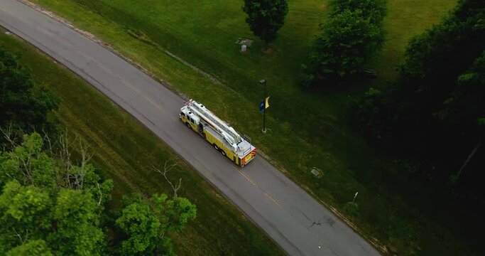 Drone shot following a fire truck along a dark rural road.