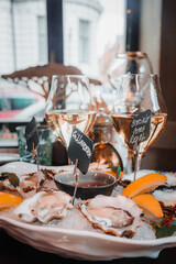Fresh Oysters close up on a plate, served table with oysters, lemon and ice. Healthy sea food. Fresh Oyster dinner with sparkling wine in a restaurant. Gourmet food