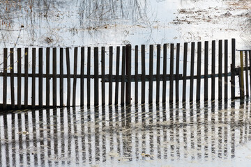 Wooden fence, hedge. picket fence and spring water spill