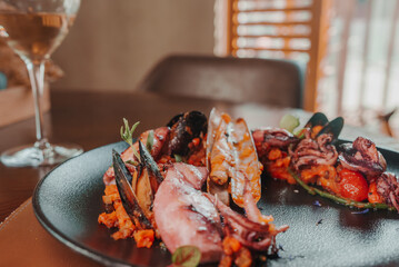 Grilled octopus with calmars, salad and lemon on plate. Close up view. © Aerial Film Studio