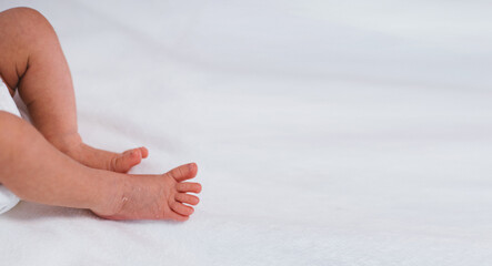 Newborn baby feet on white blanket. Cmaternity and babyhood concept.