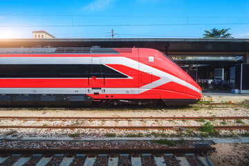 High speed train on the train station at sunny day Venice, Italy. Beautiful red modern intercity...