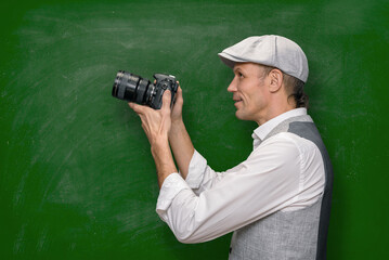 Young man teaching photographers how to develop shooting skills against green blackboard background