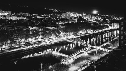 Fototapeta na wymiar Bilbao cityscape and pedestrian zubizuri bridge at night, Bilbao, Basque country, Spain.