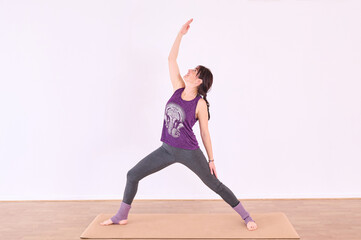 Obraz premium A young woman performing the Virabhadrasana or Warrior pose