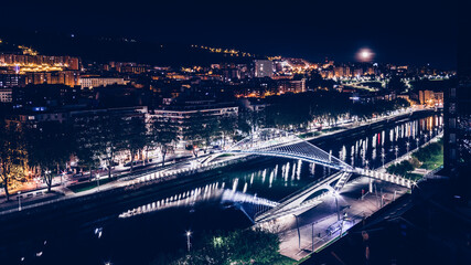 Fototapeta premium Bilbao cityscape and pedestrian zubizuri bridge at night, Bilbao, Basque country, Spain.