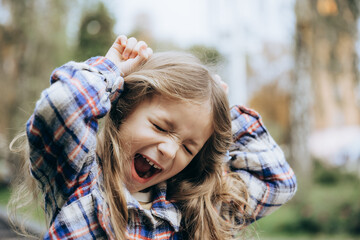 portrait of a happy and smiling little girl posing for a photo during a summer walk in the city