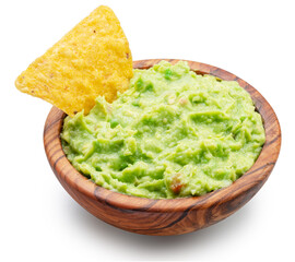 Guacamole bowl and corn chips dipped in it on white background. Top view. File contains clipping...
