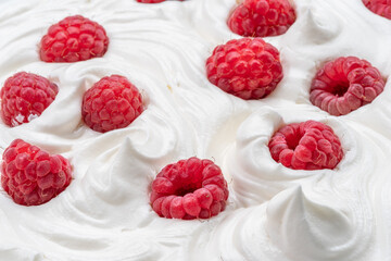Fresh raspberries in the yoghurt or cream. Top view.