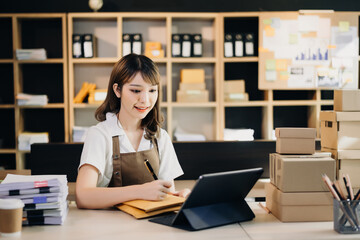 Fototapeta na wymiar Small business entrepreneur SME freelance woman working at home office, BOX,tablet and laptop online, marketing, packaging, delivery, e-commerce concept..