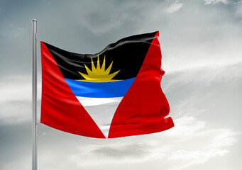 Antigua and Barbuda national flag cloth fabric waving on beautiful sky Background.