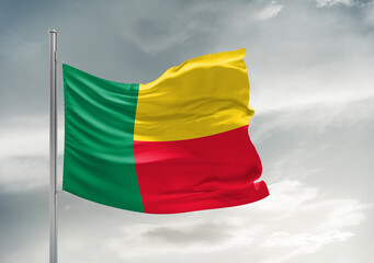 Benin national flag cloth fabric waving on beautiful sky Background.