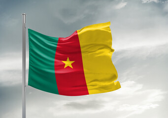 Cameroon national flag cloth fabric waving on beautiful sky Background.