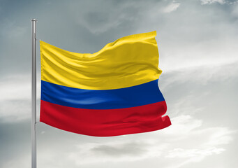 Colombia national flag cloth fabric waving on beautiful sky Background.