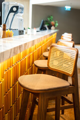 A cozy designed of tall chair in a row at counter beverage bar of the hotel lobby. Interior decoration object photo, selective focus.