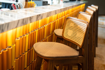 A cozy designed of tall chair in a row at counter beverage bar of the hotel lobby. Interior decoration object photo, selective focus.