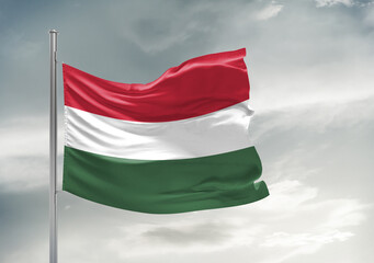 Hungary  national flag cloth fabric waving on beautiful sky Background.