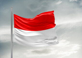 Fototapeta na wymiar Indonesia national flag cloth fabric waving on beautiful sky Background.