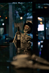 Vertical shot of a skeleton drinking wine at the bar