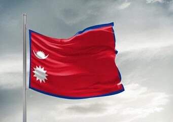 Naklejka na ściany i meble Nepal national flag cloth fabric waving on beautiful sky Background.