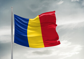 Romania national flag cloth fabric waving on beautiful sky Background.