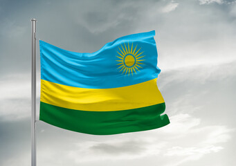 Rwanda national flag cloth fabric waving on beautiful sky Background.