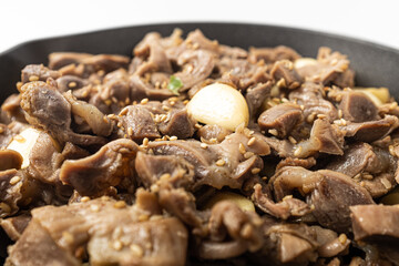 Stir-fried chicken gizzards and garlic on a white background