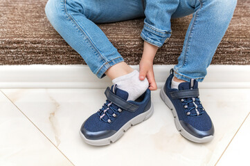 Children's hands on sneakers when putting on shoes. Close-up.