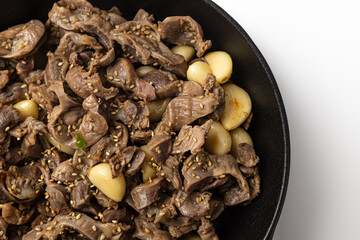 Stir-fried chicken gizzards and garlic on a white background