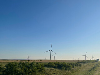 white electric power windmill in the field, alternative power generator