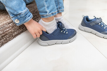 Children's hands on sneakers when putting on shoes. Close-up.