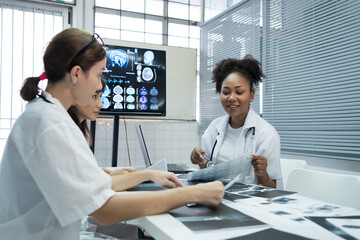 Group of female medical scientists meeting in brain research lab by monitor showing MRI, CT scans...