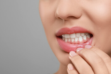 Woman showing healthy gums on grey background, closeup. Space for text